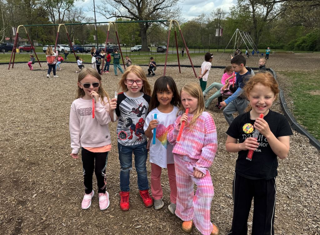 group of kids standing on the playground with popsicles