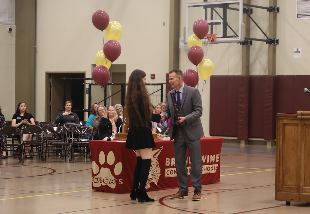 Gracie mcnamara receiving award from Evan Winkler
