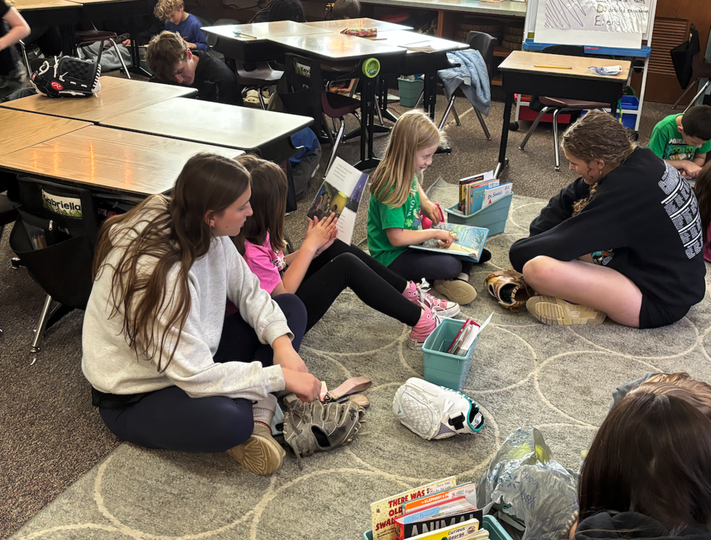 Students reading to younger students 