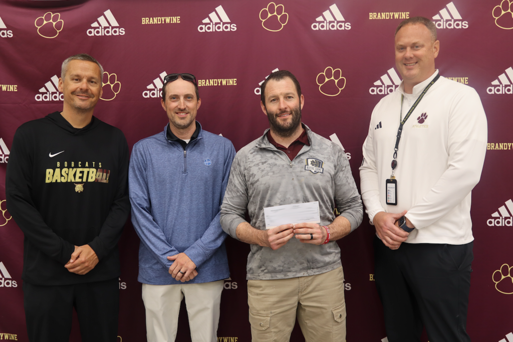 group of 4 men holding check