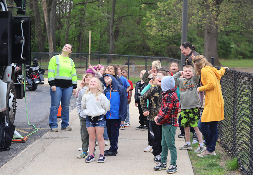 students looking up at tree truck