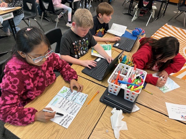 students sitting at desk, working on a computer