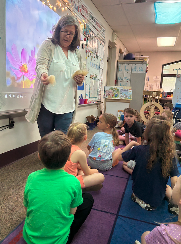 teacher showing students wool