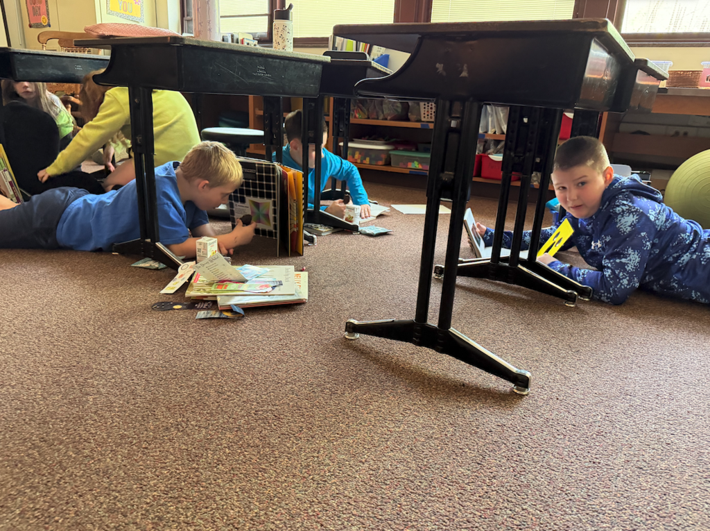 three little boys on the floor reading
