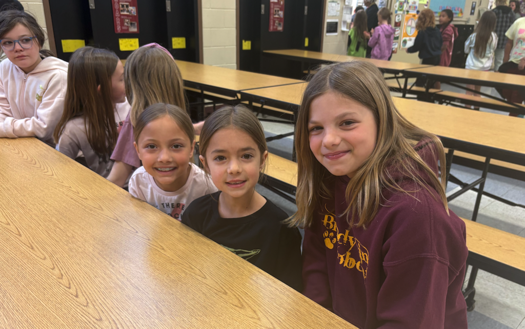 three girls sitting at lunch table