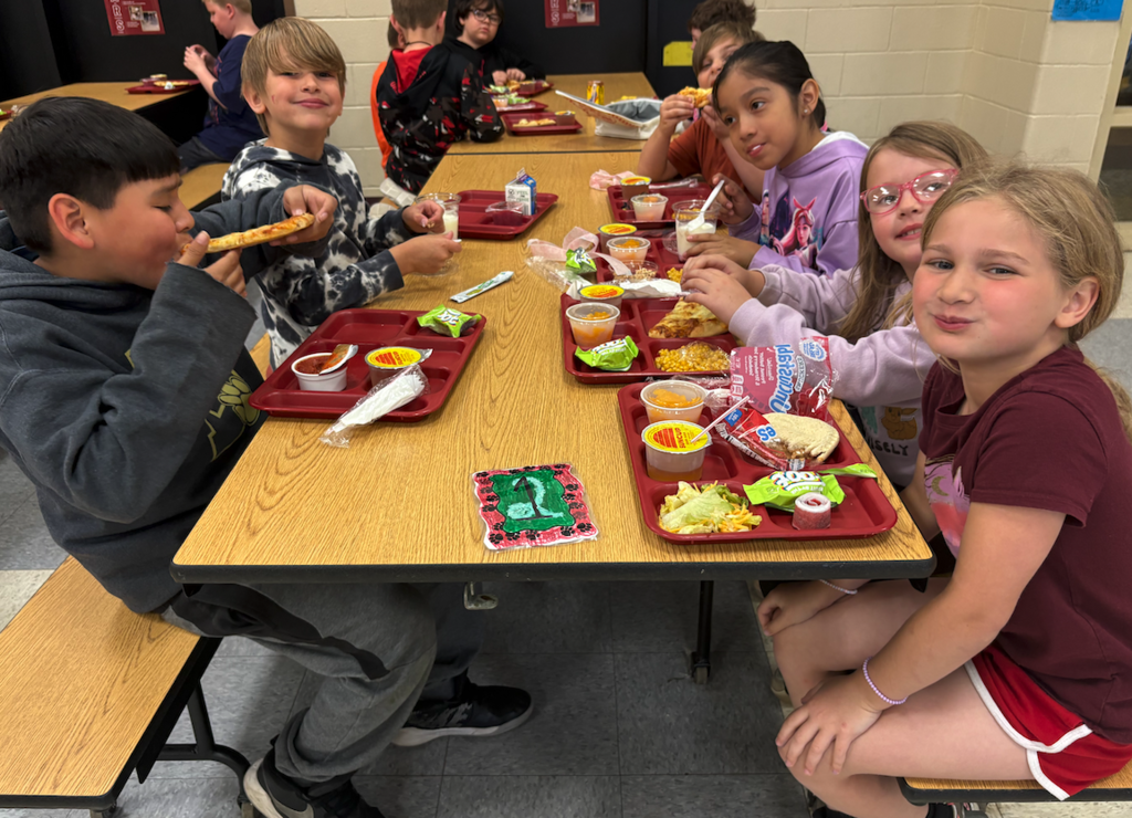 students sitting at lunch table eating