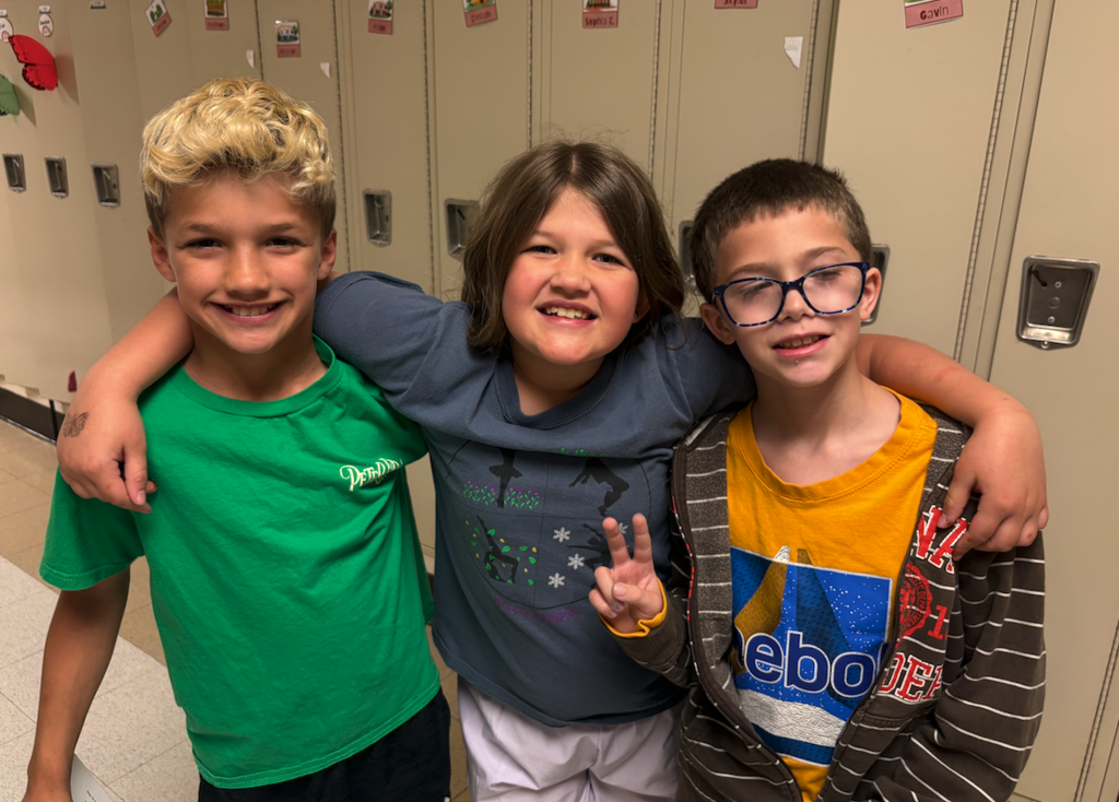 three students smiling at camera