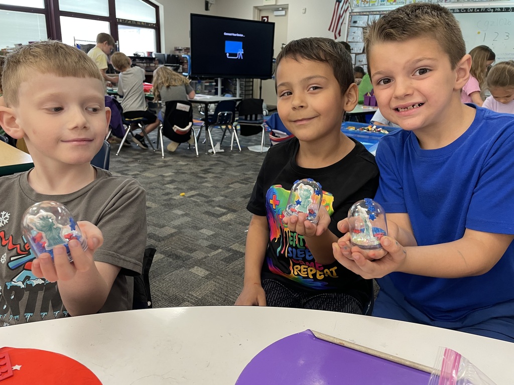 three kindergarteners showing off their craft