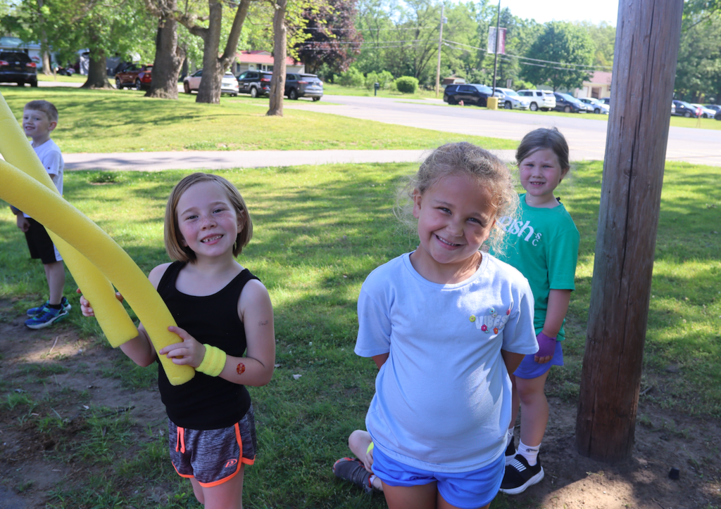 three girls smiling at camera outside