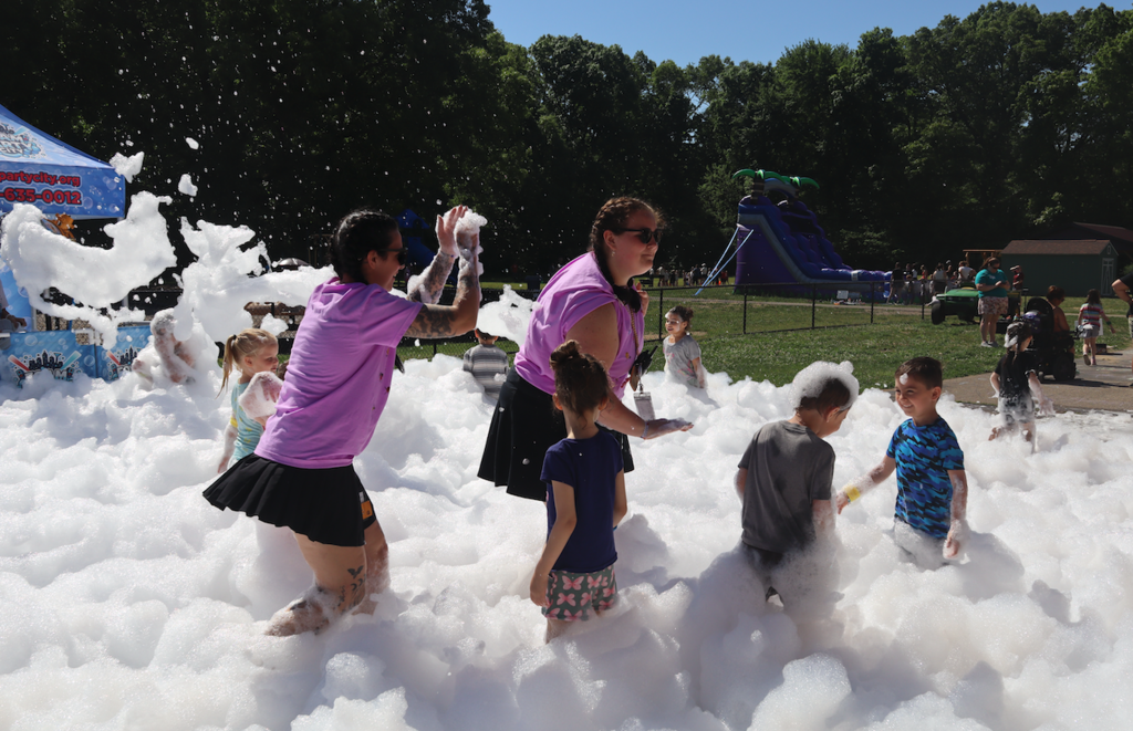 group of kids and teachers playing in foam
