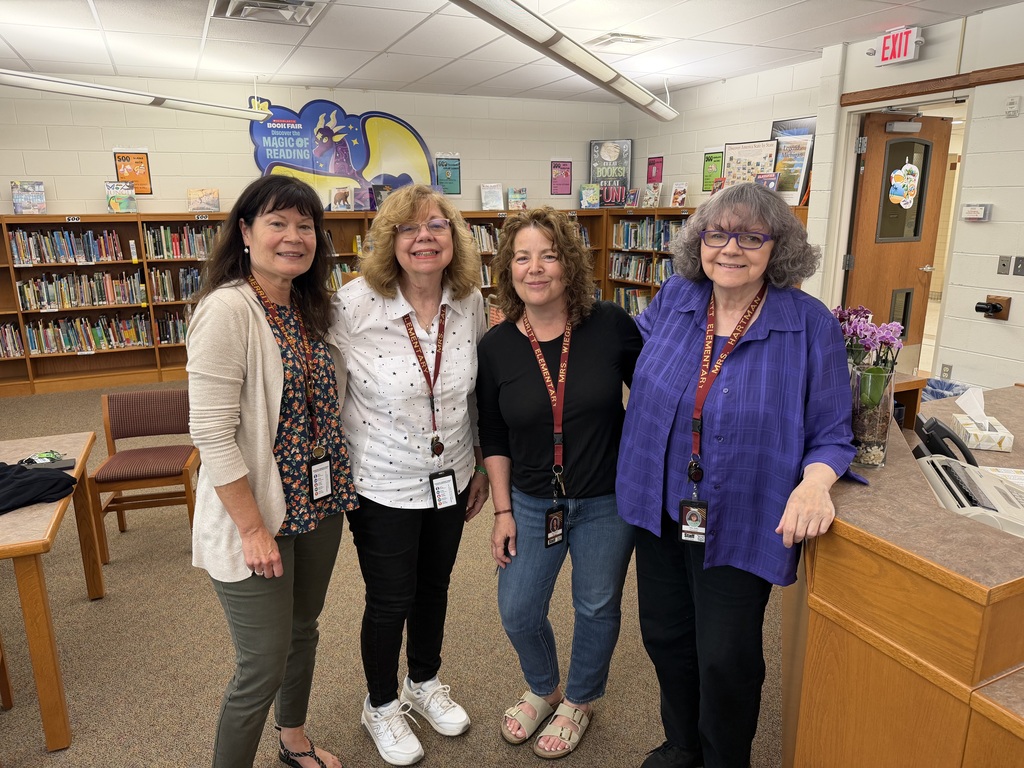 four ladies that are retiring standing library