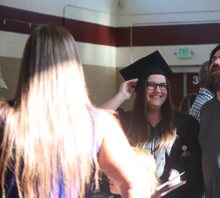 graduate talking to friends, smiling