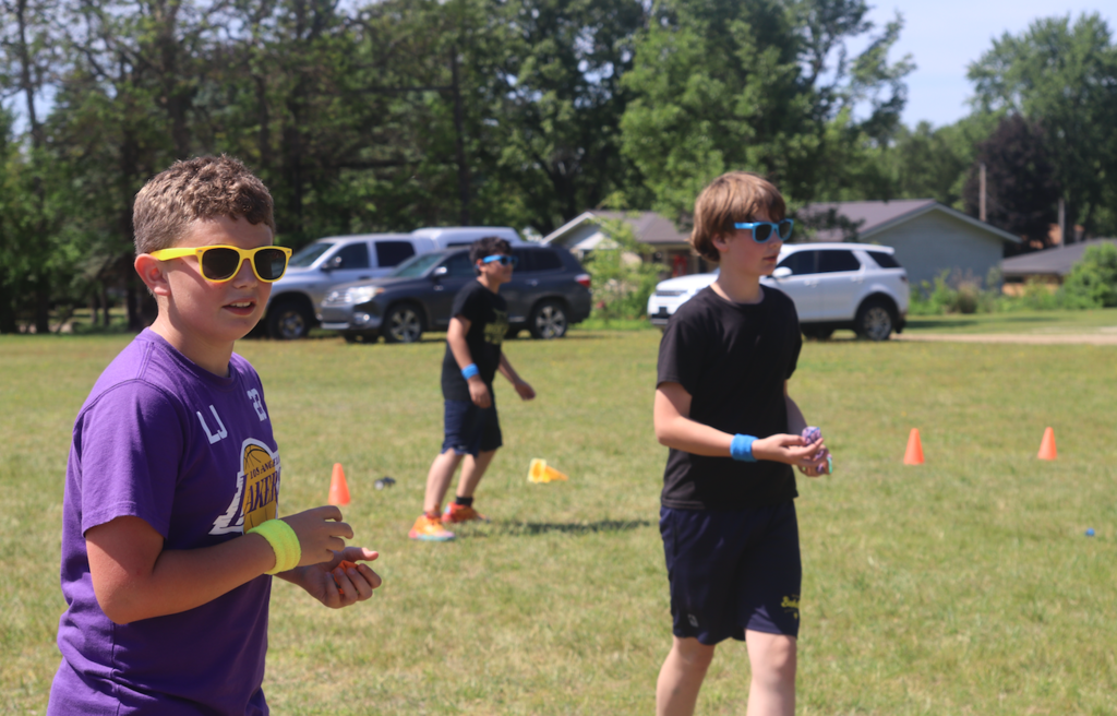 boys in sunglasses playing in the grass