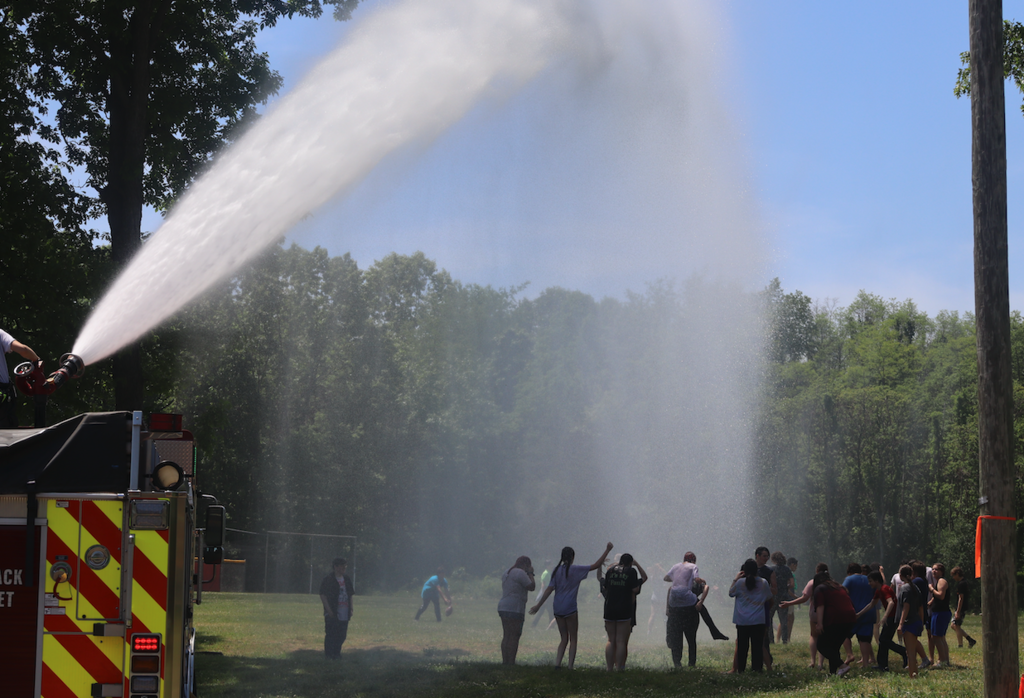 fire truck spraying water on kids