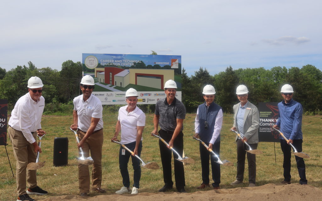 group of partners in industry holding shovels and wearing hard hats