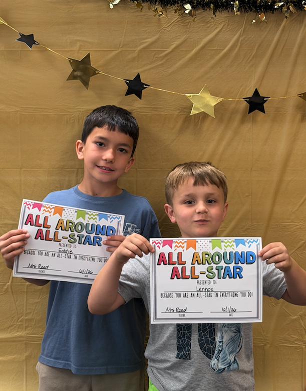 two boys holding certificates for awards