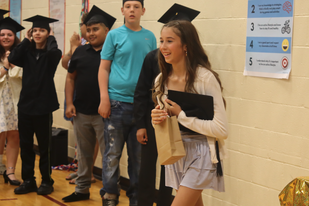 young girl walking up to get certificate
