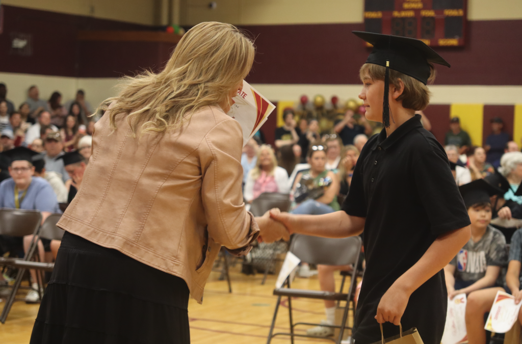 boy in graduation hat getting his certificate