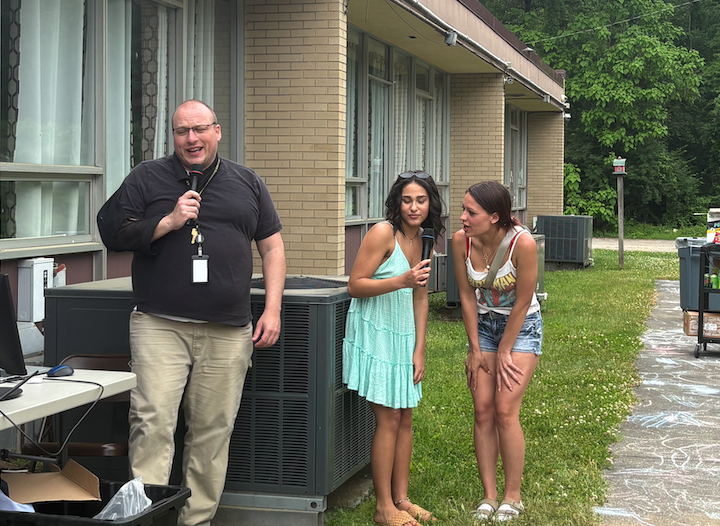 three people doing karaoke outside