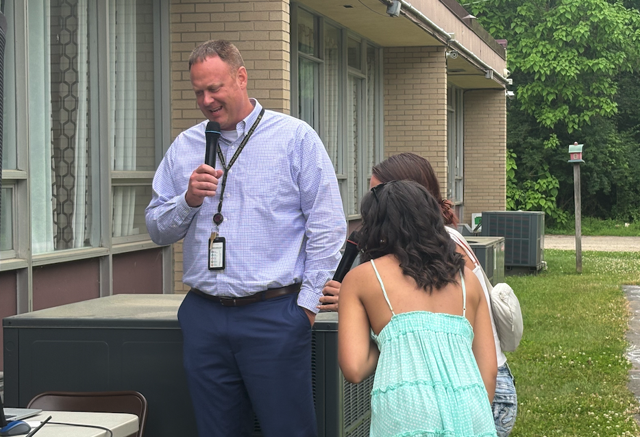 three people doing karaoke outside
