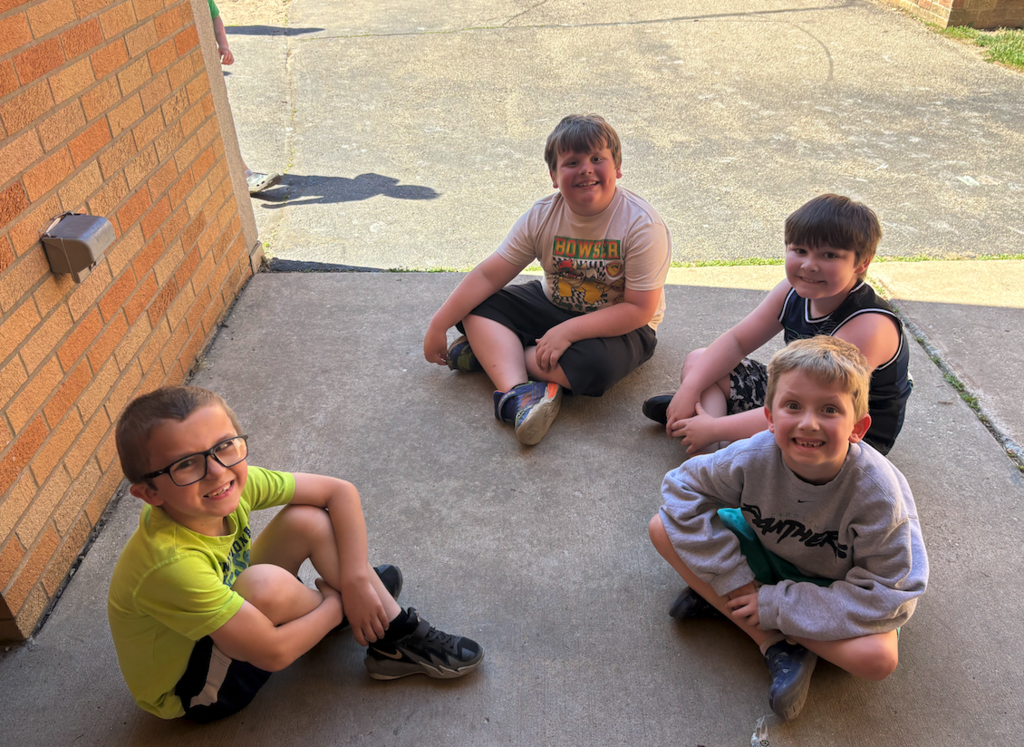 four boys sitting on the playground
