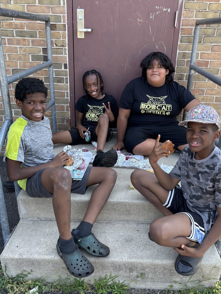 four kids sitting outside eating lunch