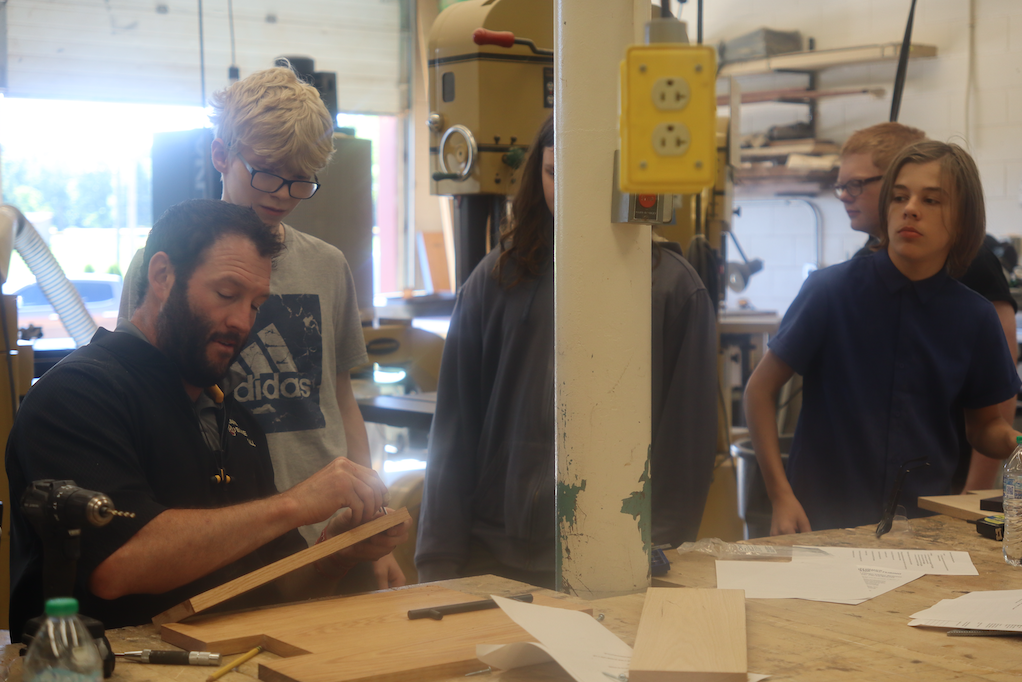 teacher showing students wooden pieces