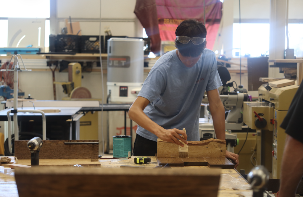 student working on painting woodshop project