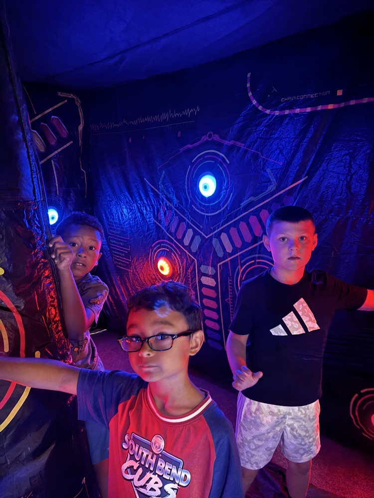 three kids in black light room