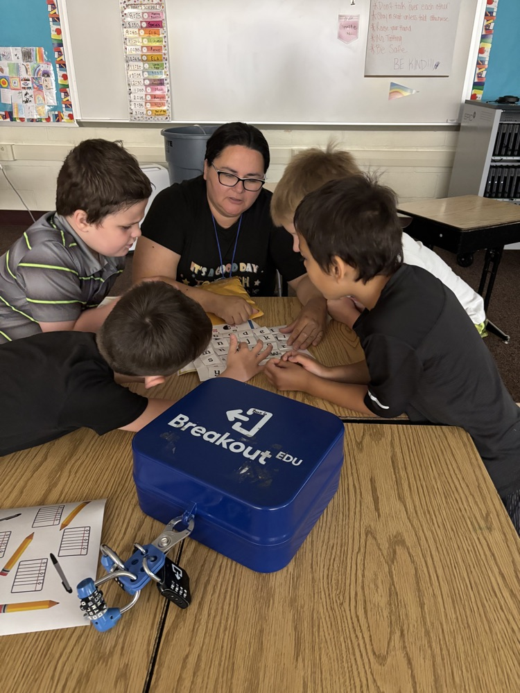 teacher working with 4 kids at a table