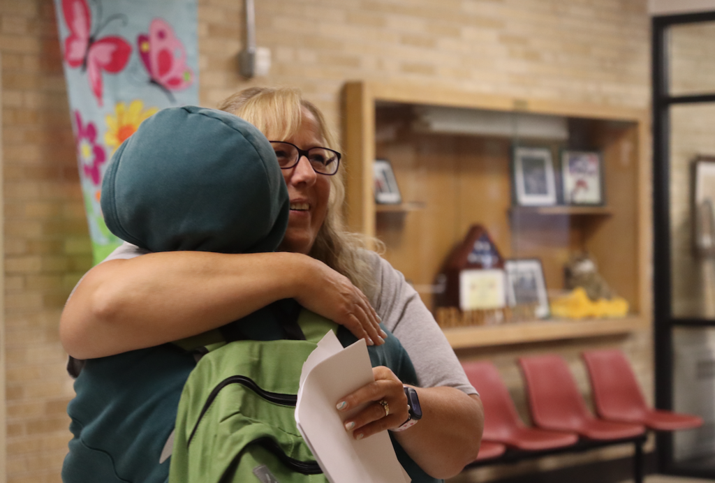 a teacher giving a student a hug