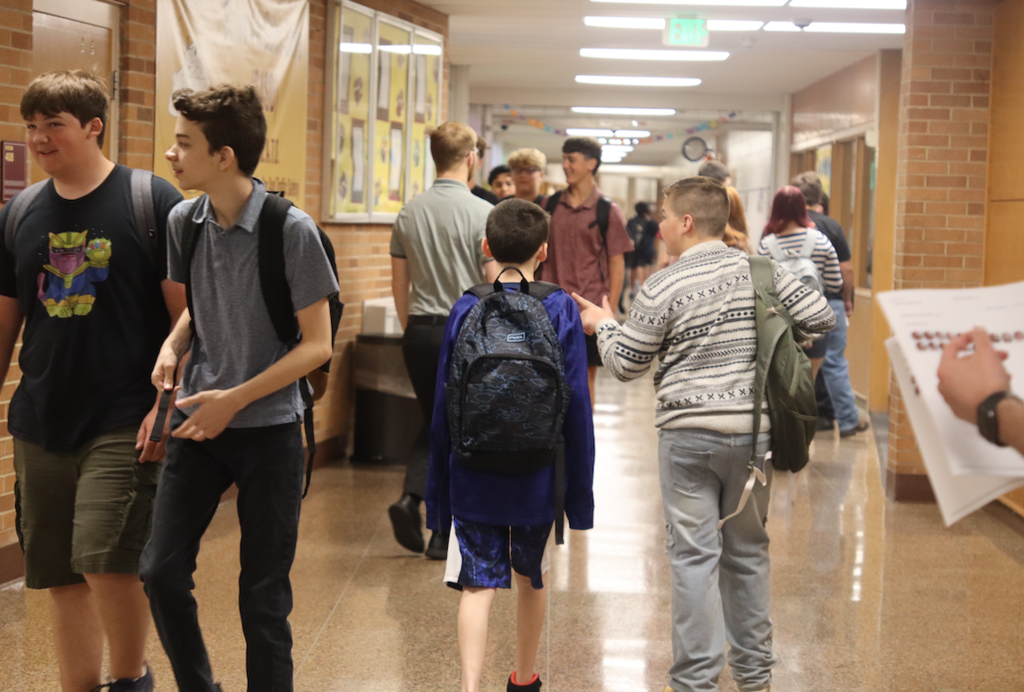 two boys walking down hallway talking