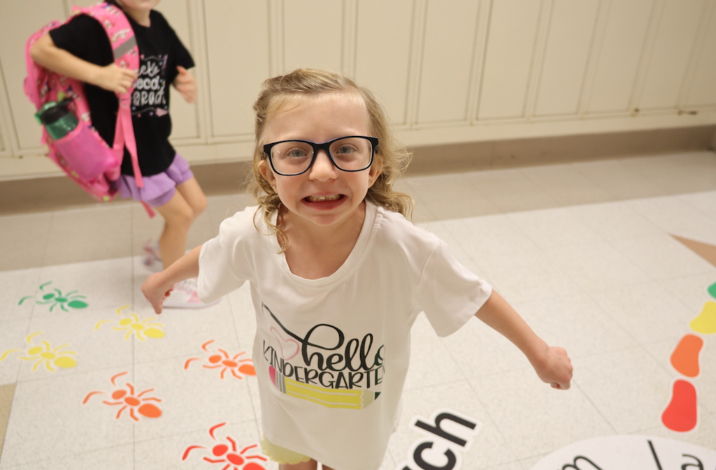 little girl in kindergarten shirt smiling