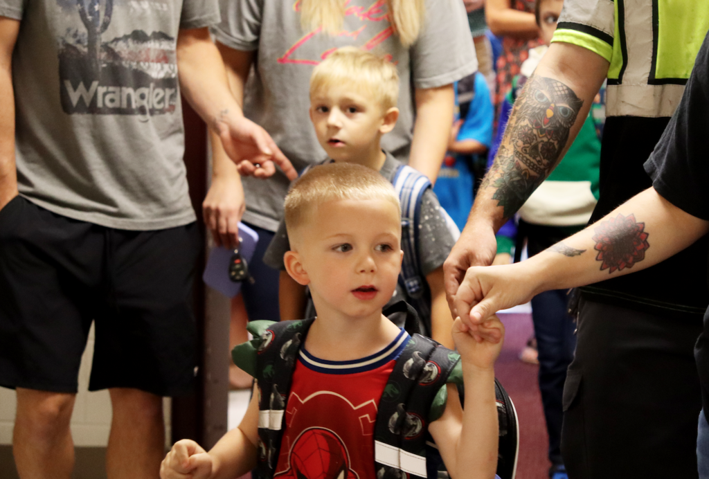 little boys walking in with parents to school