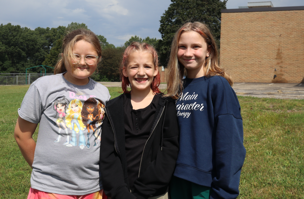 three girls smiling at the camera