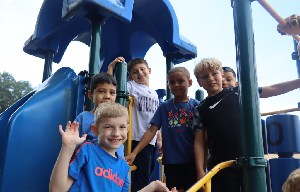 6 boys standing on the playground equipment