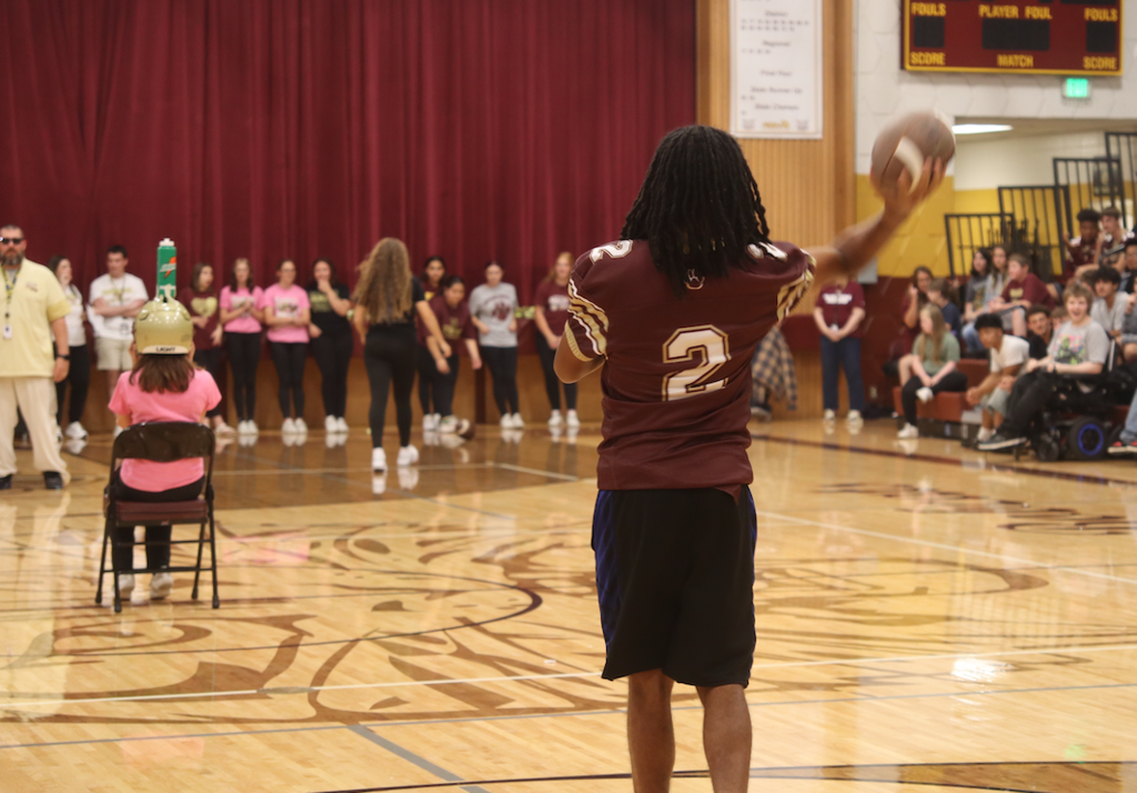 football player throwing a football in gym