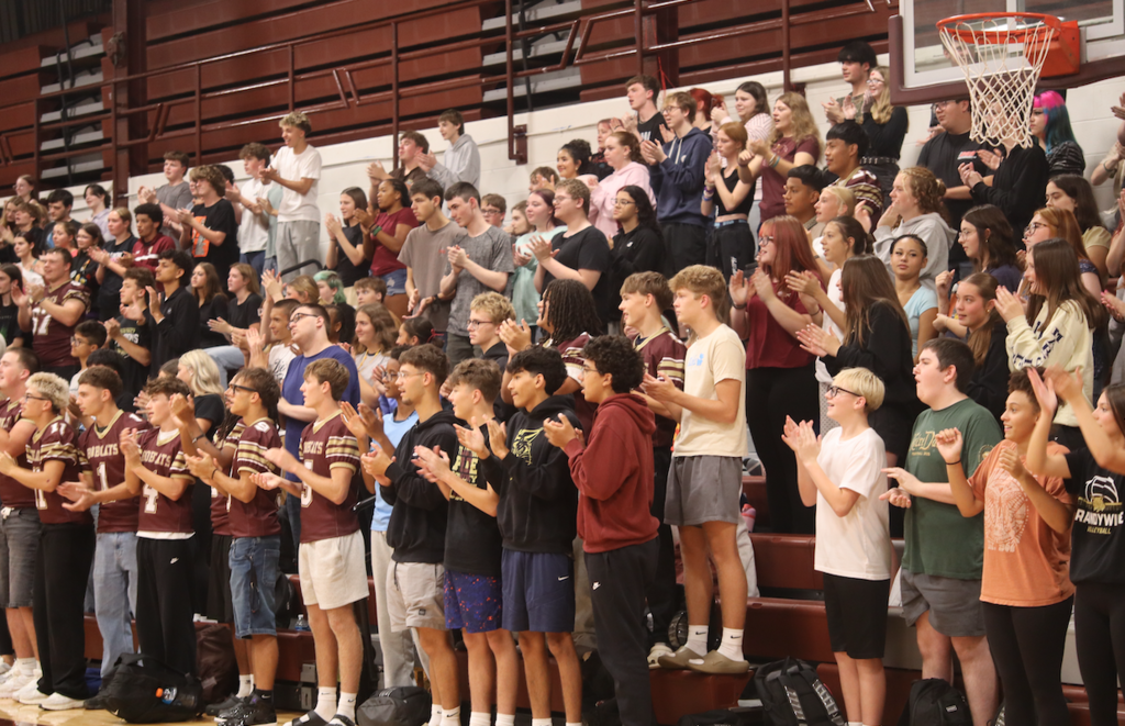 group of students standing and clapping in stands