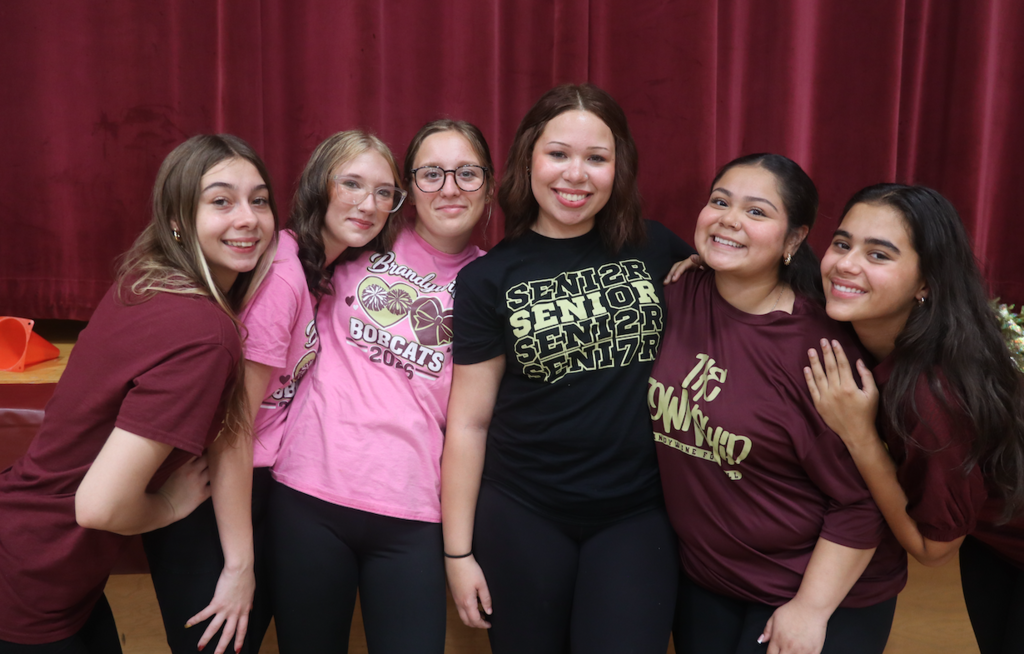 6 girls standing together, wearing spirit shirts.