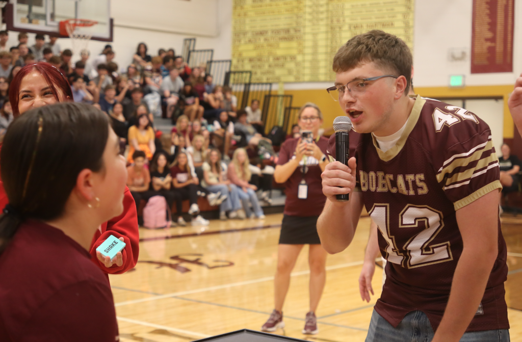 student singing, wearing football uniform