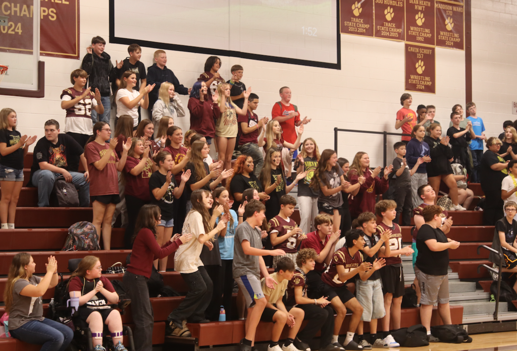 group of students, in stands, cheering