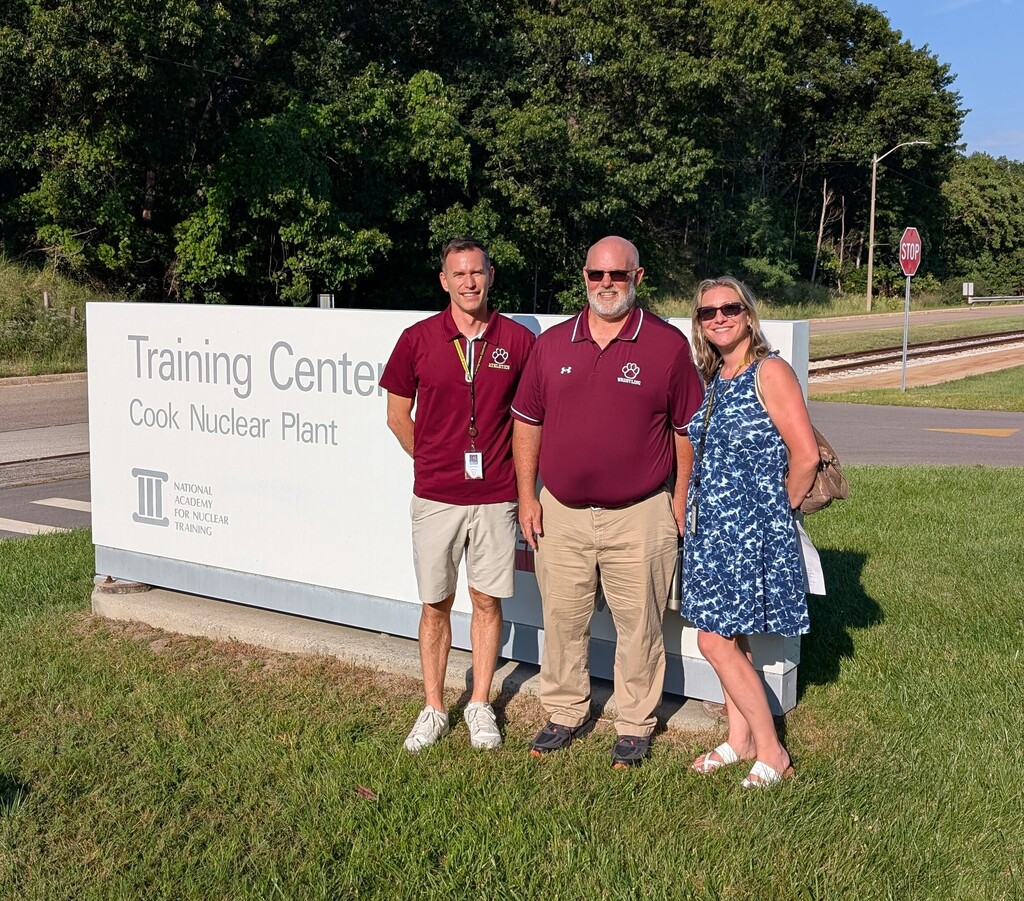 evan, mr. pomranka, and ms. lezotte in front of cook nuclear plant sign