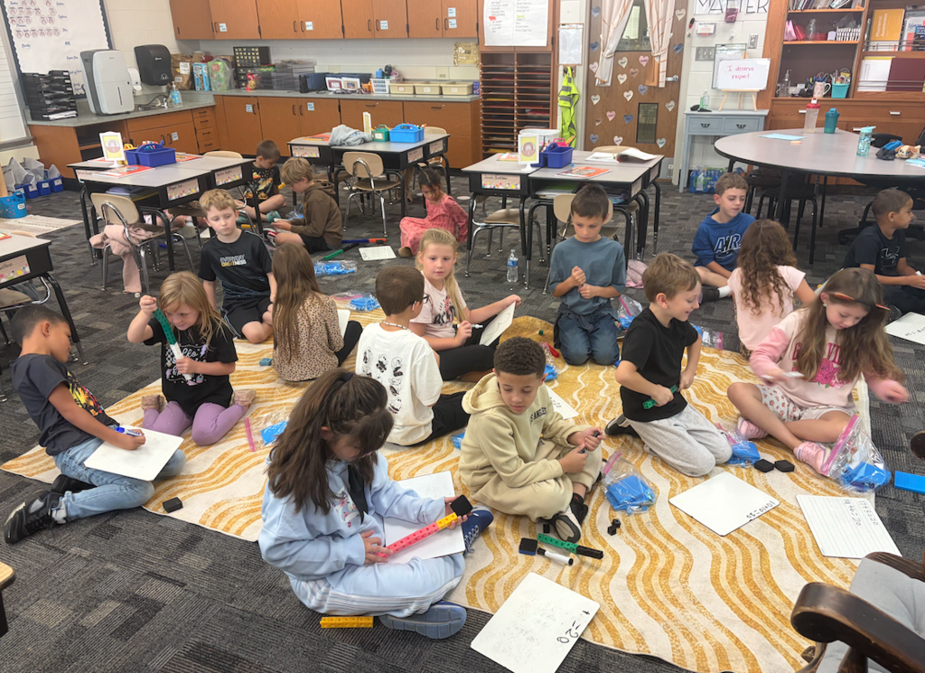 class sitting on floor doing math