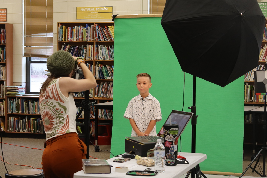 boy taking picture for picture day in front of camera