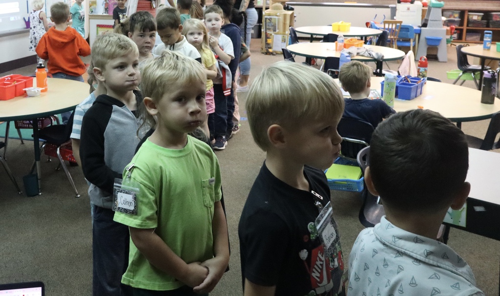 kids standing in line with bubble in their mouth