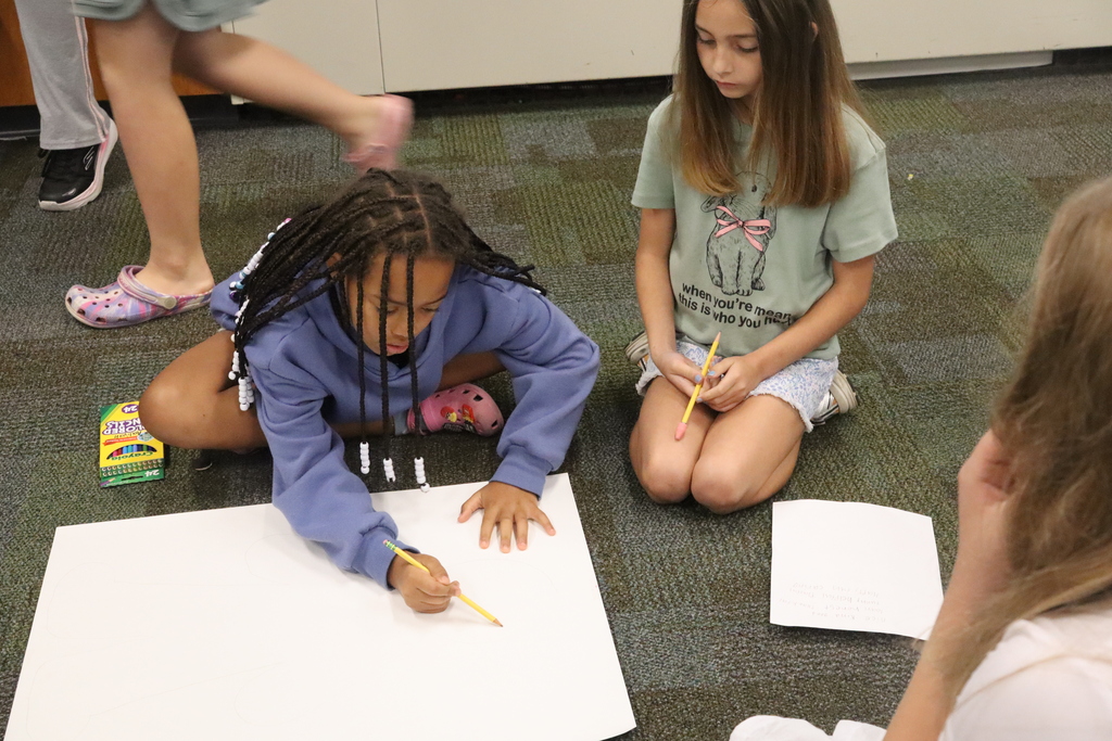 little girls drawing on a poster board