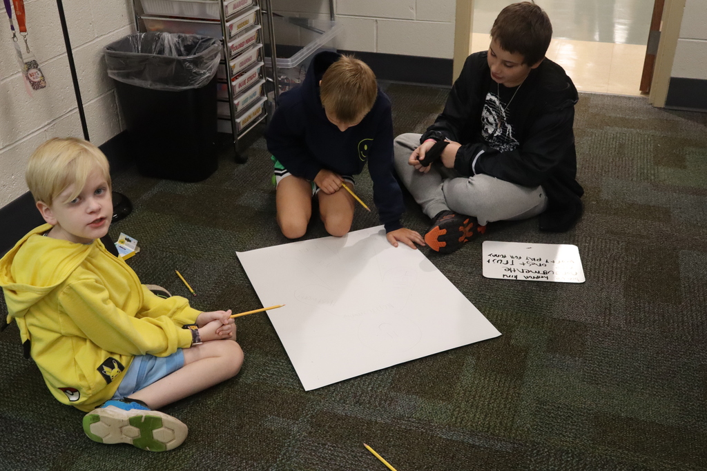 group of boys drawing on a posterboard