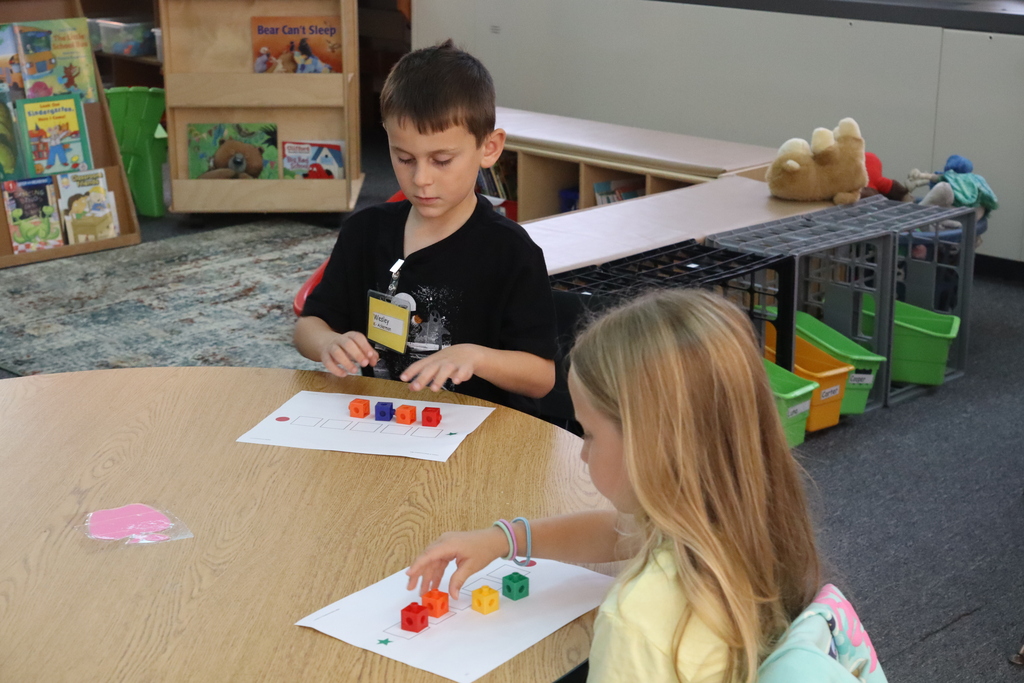 a little boy and a little girl counting blocks