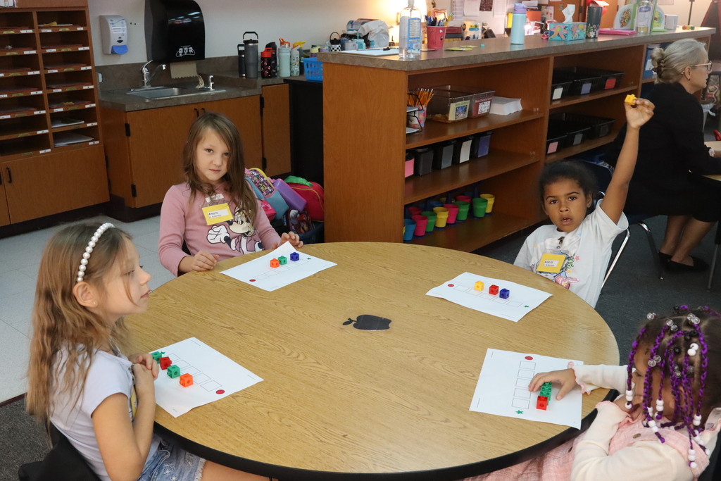 little girls sitting at the table counting blocks