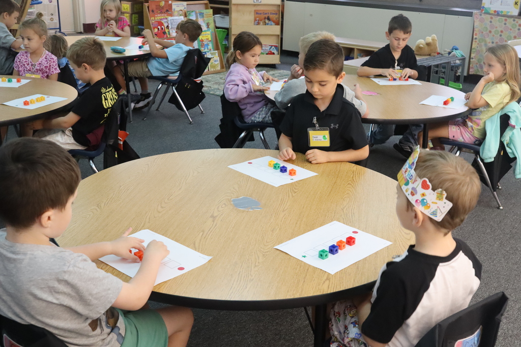 threel ittle boys at the table counting letter blocks
